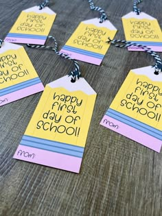 four tags with the words happy friday school on them sitting on a wooden table top