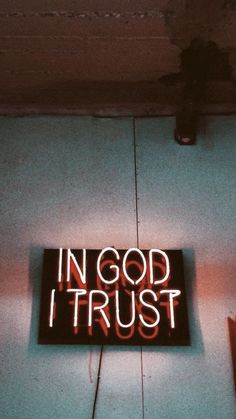 a neon sign that says in god i trust