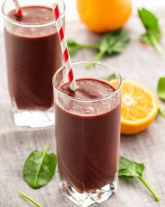 two glasses filled with chocolate smoothie next to oranges