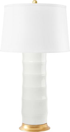 a white table lamp with a gold base and a white lampshade on top