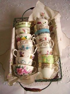 there are many cups and saucers in the basket