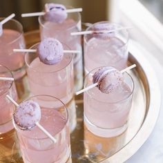 there are many pink drinks on the table with sticks sticking out of them and ice cream