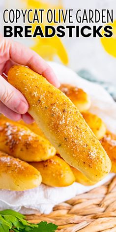 a person is picking up some breadsticks from a basket with parsley on the side