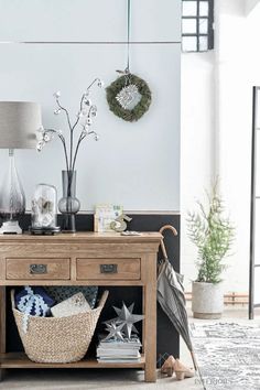 a wooden table topped with a basket next to a lamp