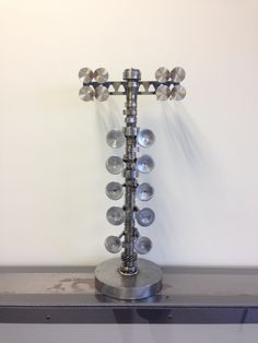 a metal candle holder sitting on top of a shelf next to a white wall with lots of glass balls