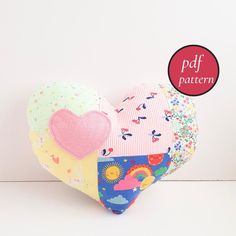 a patchwork heart shaped pillow sitting on top of a table