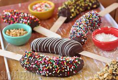 chocolate dipped donuts with sprinkles and bowls of cereal on a tray