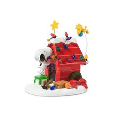 a small toy house with a dog on the roof and other toys around it in front of a white background