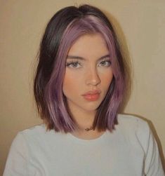 a woman with purple hair is looking at the camera