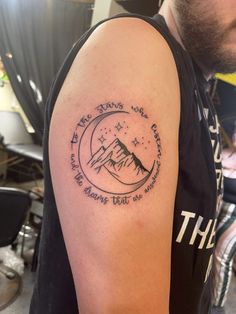 a man with a tattoo on his arm that says, the mountains are calling you