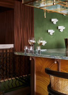 a bar with wine glasses on it and paper airplanes hanging from the wall behind it