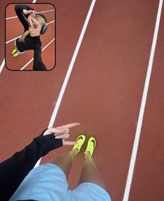 a woman in black shirt and yellow shoes on a red running track with headphones