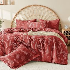 a bed with red sheets and pillows in a room