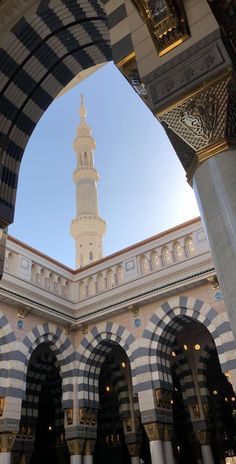 the inside of an ornate building with arches and columns, looking up at a clock tower