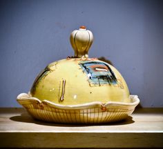 a yellow vase sitting on top of a wooden table