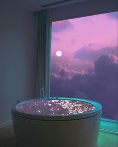 a bathtub sitting in front of a window with the view of the sky and clouds