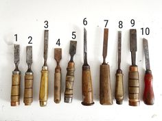 several different types of woodworking tools lined up on a white wall with numbers in the middle