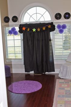 there is a purple rug on the floor in front of a window with stars and pom poms