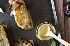 two grilled sandwiches are on a tray with dipping sauce