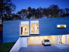 a car is parked in front of a house with windows on the side and stairs leading up to it