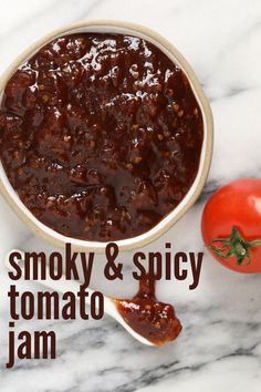 a bowl of smoky and spicy tomato jam next to a tomato