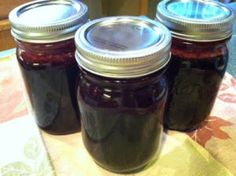 three jars filled with jam sitting on top of a table