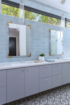 Contemporary Bathroom with Blue Stacked Backsplash and Patterned Floor The flat-panel gray vanity with a quartz countertop provides plenty of storage space, besides its visual beauty. Wood Backsplash, Gray Vanity, White Subway Tiles, Wooden Vanity, Marble Vanity, Quartz Countertop, Grey Panels