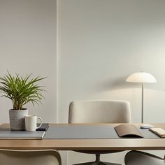 a desk with a book, coffee cup and potted plant sitting on top of it