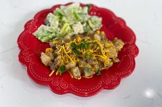 a red plate topped with food on top of a table