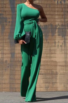 One Shoulder Jumpsuit - Dark Green This jumpsuit is a statement in itself! Perfect for date night or brunch with the ladies! This green jumpsuit comes in a wide pant leg featuring a long sleeve one shoulder, adjustable tie belt, and side zipper. Pair this with a stylish heel and handbag for a complete look. One Shoulde Green Long Sleeve Jumpsuits And Rompers For Party, Green Long Sleeve Party Jumpsuits, Chic Green Long Sleeve Jumpsuits And Rompers, Green Wide Leg Jumpsuits For Party, Green Wide Leg Jumpsuits And Rompers For Party, Green Wide-leg Jumpsuits For Party, One-shoulder Jumpsuits And Rompers For Spring Date Night, Chic Spring Pantsuit With Tie Waist, Elegant Green Strapless Jumpsuit For Night Out