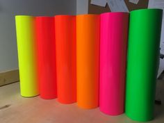 four rolls of colored paper sitting on top of a table