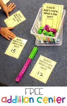 a table topped with lots of different types of letters and numbers on paper next to a plastic container filled with magnets