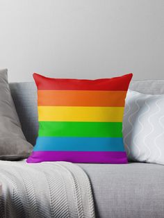 a rainbow colored pillow sitting on top of a couch