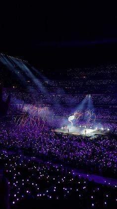 the stage is lit up with purple lights and confetti in front of an audience