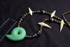 This necklace was inspired by Japanese Culture and Anime Culture. It features a Green Resin Magatama Focal and Resin Dragon Teeth. There are Genuine Malachite, Faint Rainbow Obsidian, and Wood beads featured around the necklace. It is about 34" long and strung on 49 strand nylon coated stainless steel wire. Dragon Priestess, Fantasy Amulet, Sleepless Domain, Amethyst Princess Of Gemworld, Dragon Teeth, Resin Dragon, Rainbow Obsidian, Teeth Jewelry, Magical Jewelry