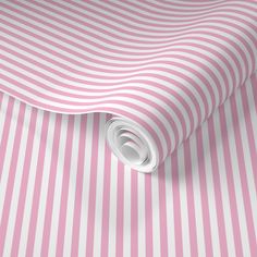 a pink and white striped wallpaper with a rolled up roll on the floor next to it