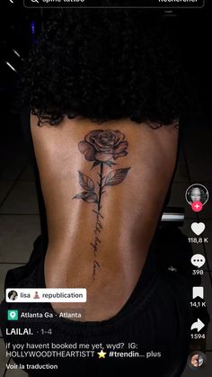 the back of a woman's lower back tattoo with roses and words on it