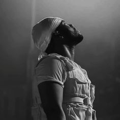 a man with a turban on his head standing in front of a light