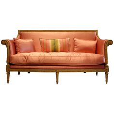 an orange couch with some pillows on it