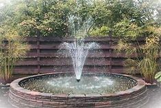 a water fountain in the middle of a garden