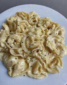 a white plate topped with pasta covered in sauce