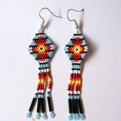 a pair of beaded earrings with flowers and beads hanging from it's hooks