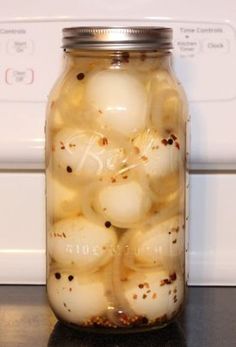 a jar filled with onions sitting on top of a counter