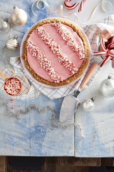 a pie with red and white sprinkles on it sitting on top of a table