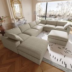 a large sectional couch sitting on top of a wooden floor in front of a window