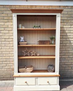 a white bookcase with wooden shelves and drawers