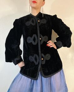 "Victorian Velvet. Phenomenal Antique Edwardian/Victorian black velvet jacket with stunning cloisonné buttons, braided rope details, blouson sleeves with extra wide cuffs, and the most incredible ivory silk lining with embroidered boarder. She's full of details & absolutely incredibly wearable. I'm in awe.  Fits L (I'm about a M), but please use measurements as fit guide. 16.25\" shoulder  20\" bust (on the half)  19.5\" waist (on the half)  22.25\" hip (on the half)  23.25\" sleeve 30\" length  Fully lined in silk - ivory  Velvet  Center front loop metal cloisonné button closures  Princess seams front and back  Gathered shoulder caps  3 piece big blouson sleeves with pleating details and wide cuff with gathering  Braided trim throughout exterior front, back and sleeve cuffs  Interior embr Victorian Black Outerwear With Buttons, Black Victorian Outerwear With Buttons, Long Sleeve Velvet Outerwear For Costume, Long Sleeve Velvet Costume Outerwear, Velvet Costume Outerwear For Fall, Velvet Outerwear For Costume, Black Velvet Costume Outerwear, Winter Velvet Costume Outerwear, Winter Velvet Outerwear