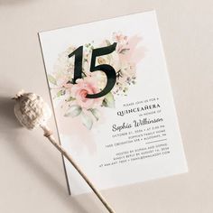 a white and pink floral birthday party card with the number five on it, next to a lollipop