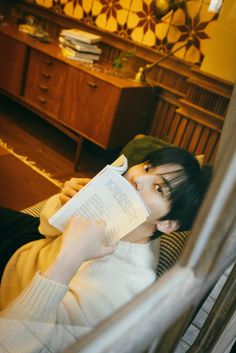 a woman laying on the floor reading a book