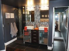 a bathroom with two sinks, mirrors and lights on the wall next to each other